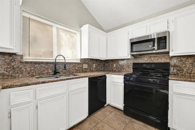 a kitchen with stainless steel appliances granite countertop a stove microwave and sink
