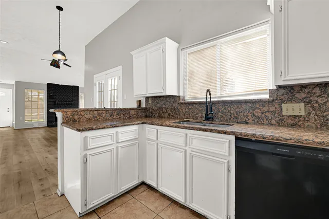 a kitchen with granite countertop cabinets stainless steel appliances a sink and a window