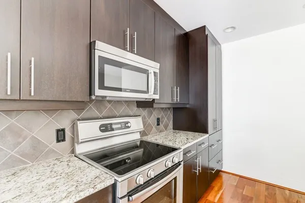 a kitchen with granite countertop a stove and a microwave