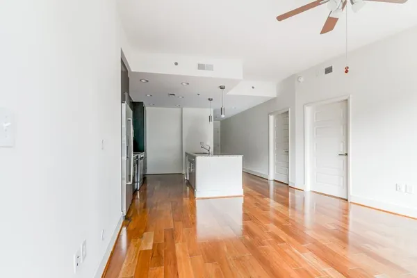 a view of an empty room with wooden floor