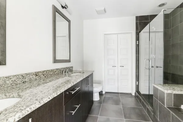 a bathroom with a granite countertop sink a mirror and a shower