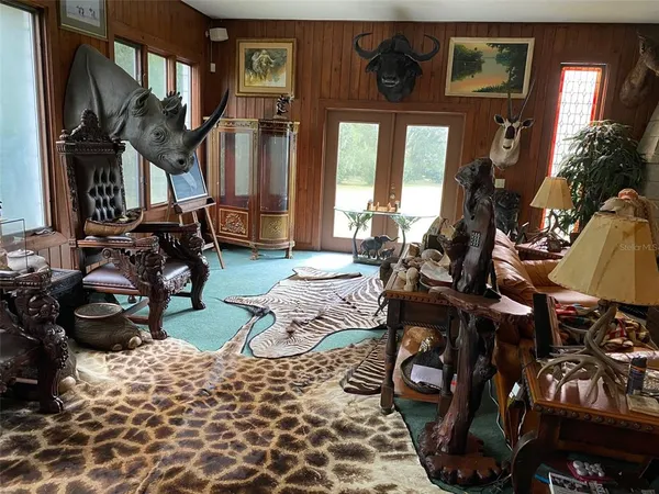 a living room with furniture a flat screen tv and a floor to ceiling window