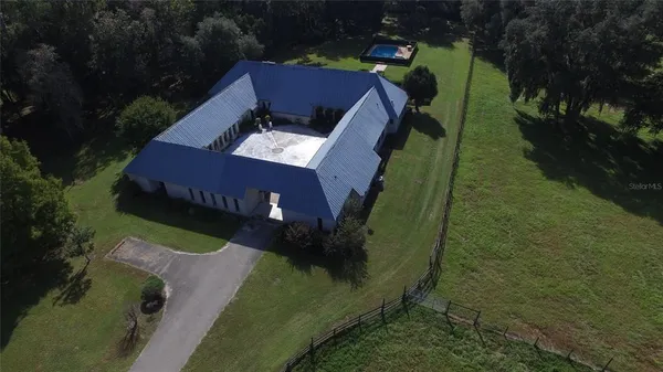 an aerial view of residential houses with outdoor space and trees