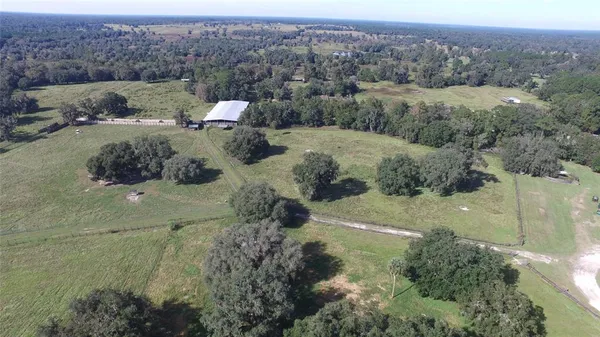 an aerial view of house with yard and mountain view in back