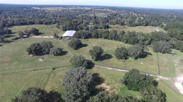 an aerial view of house with yard and mountain view in back