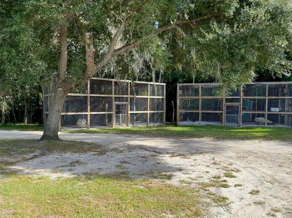 a front view of house with yard and trees in the background