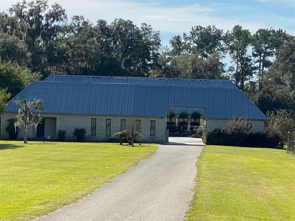 a view of a house with pool and a yard