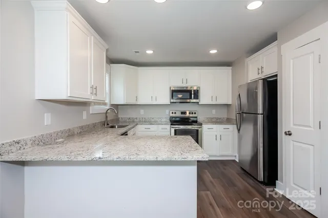 a kitchen with stainless steel appliances granite countertop a refrigerator sink and stove