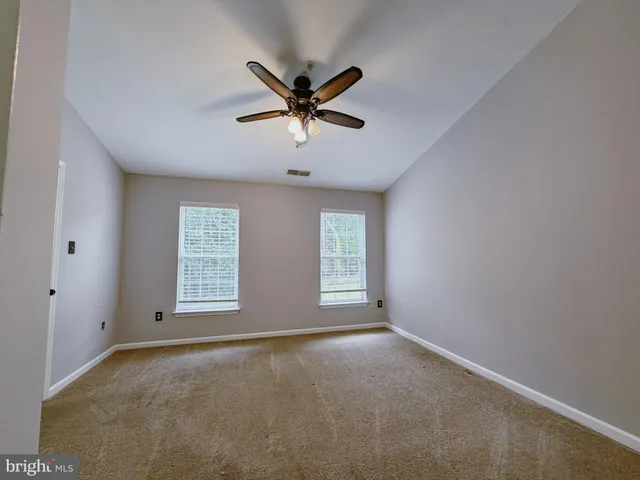 a view of a livingroom with a ceiling fan and window