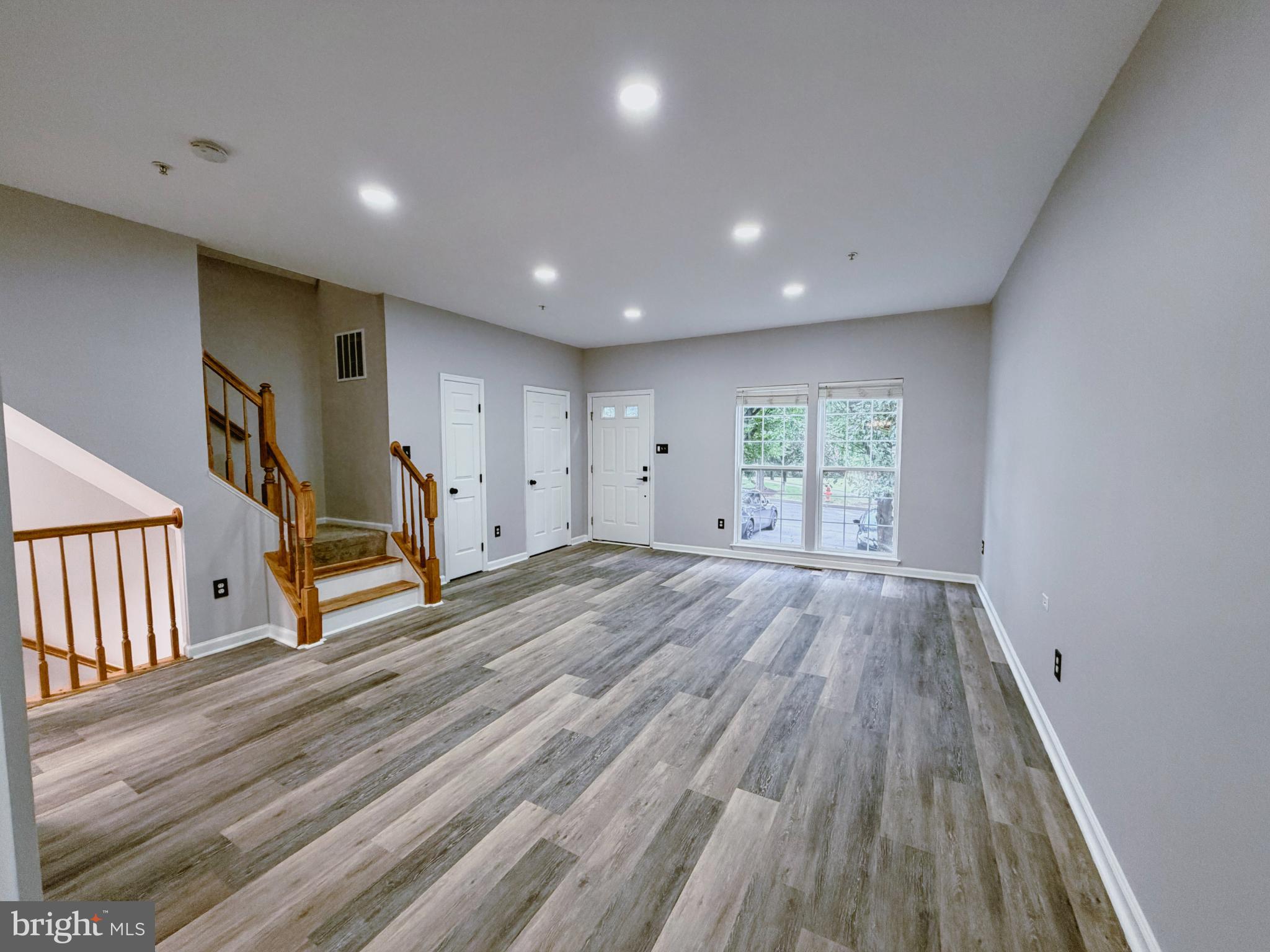 9837 Sherwood Farm Road Owings Mills, MD 21117 - Photo 3 of 27 an empty room with wooden floor staircase and windows