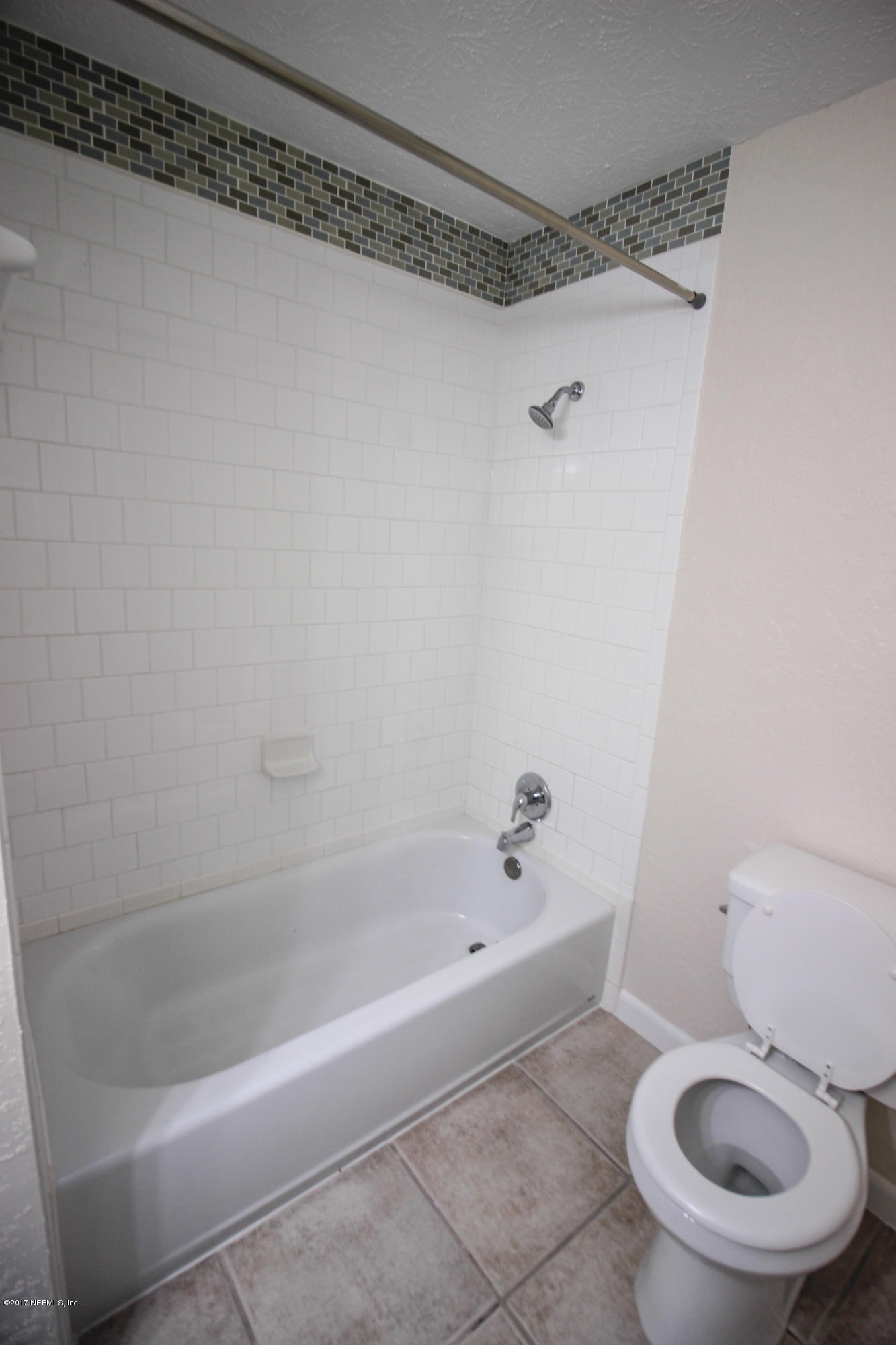 4134 Rogero Road Jacksonville, FL 32277 - Photo 15 of 36 a bath room with a toilet and a bath tub