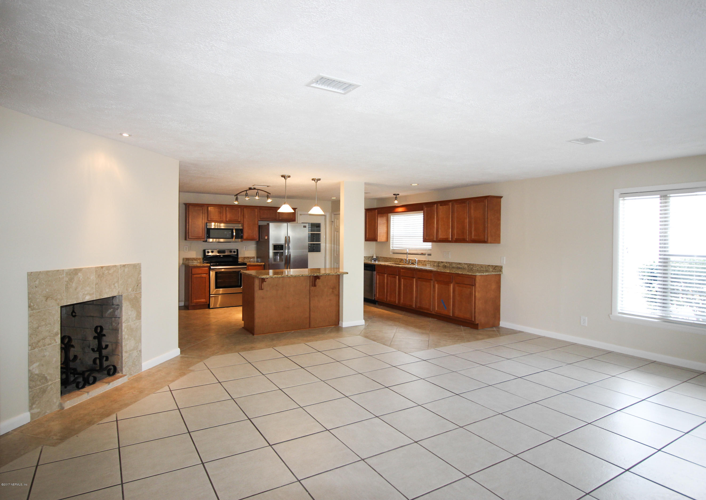 4134 Rogero Road Jacksonville, FL 32277 - Photo 2 of 36 a kitchen with stainless steel appliances kitchen island granite countertop a refrigerator and a stove top oven