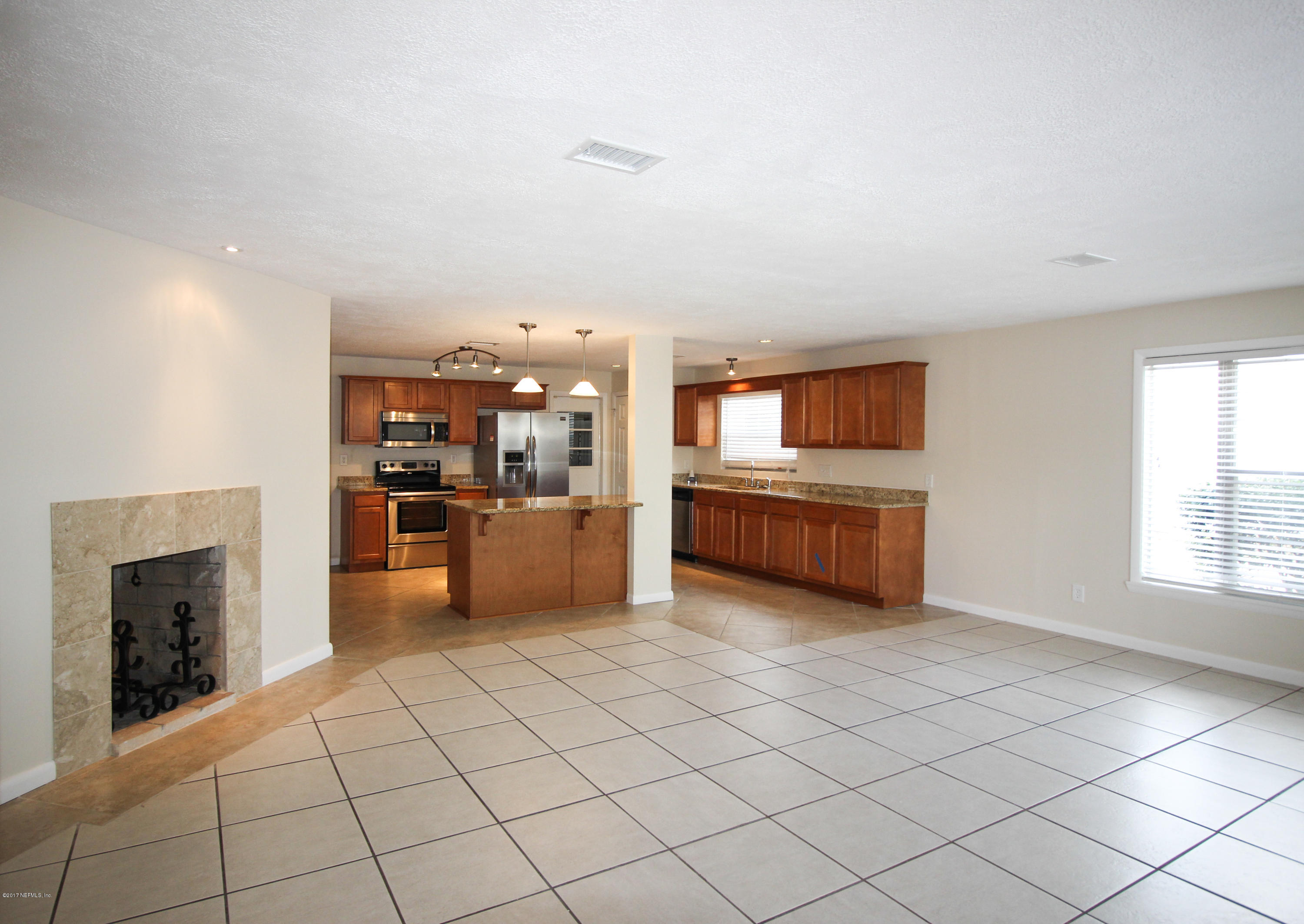 4134 Rogero Road Jacksonville, FL 32277 - Photo 3 of 36 a kitchen with stainless steel appliances kitchen island granite countertop a refrigerator and a stove top oven
