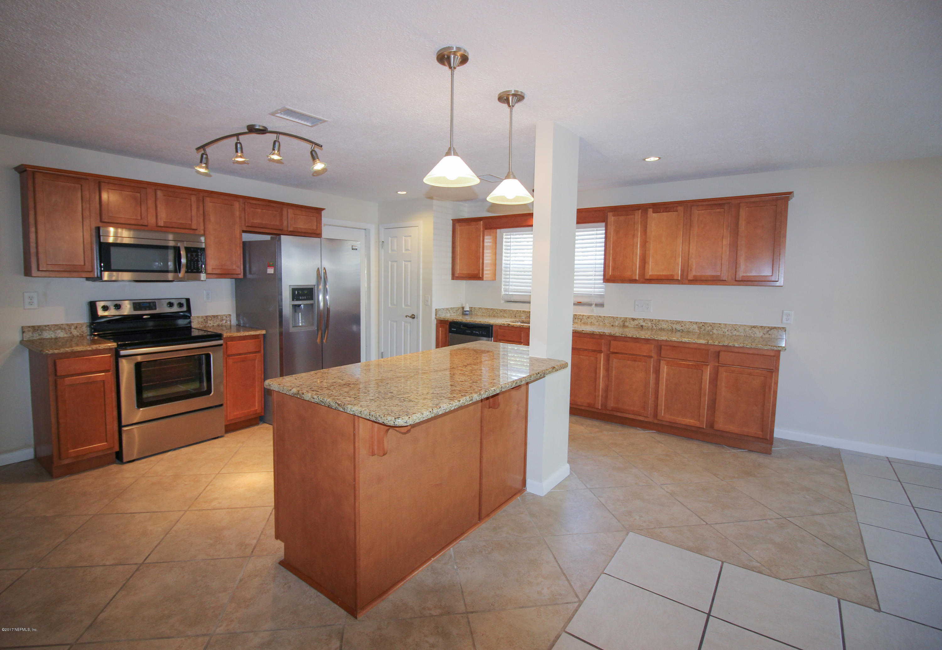 4134 Rogero Road Jacksonville, FL 32277 - Photo 35 of 36 a kitchen with stainless steel appliances granite countertop a sink counter space cabinets and a large window
