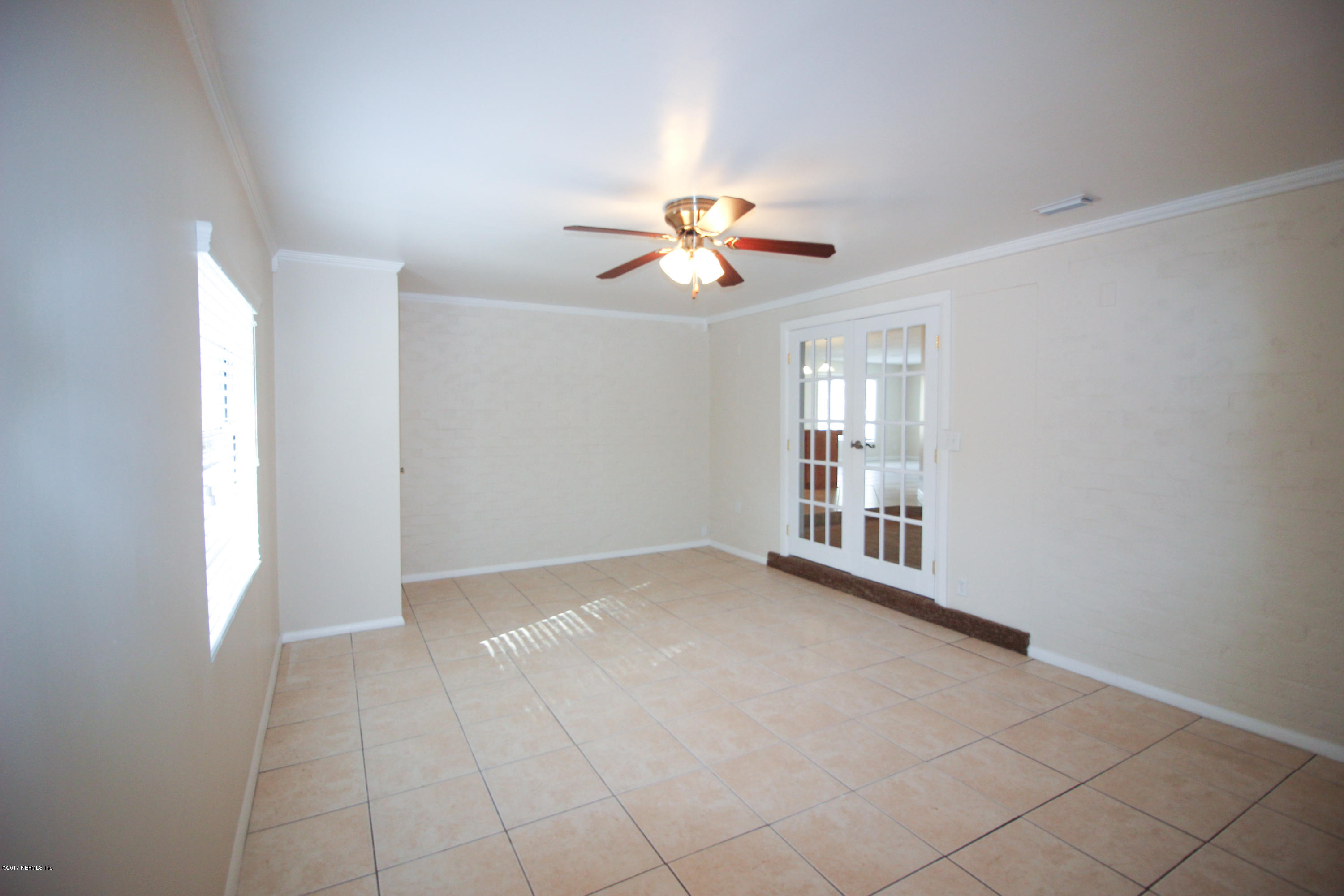 4134 Rogero Road Jacksonville, FL 32277 - Photo 8 of 36 a view of an empty room with a ceiling fan and window