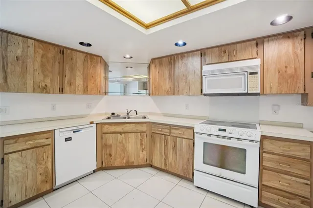 a kitchen with granite countertop white cabinets and white appliances