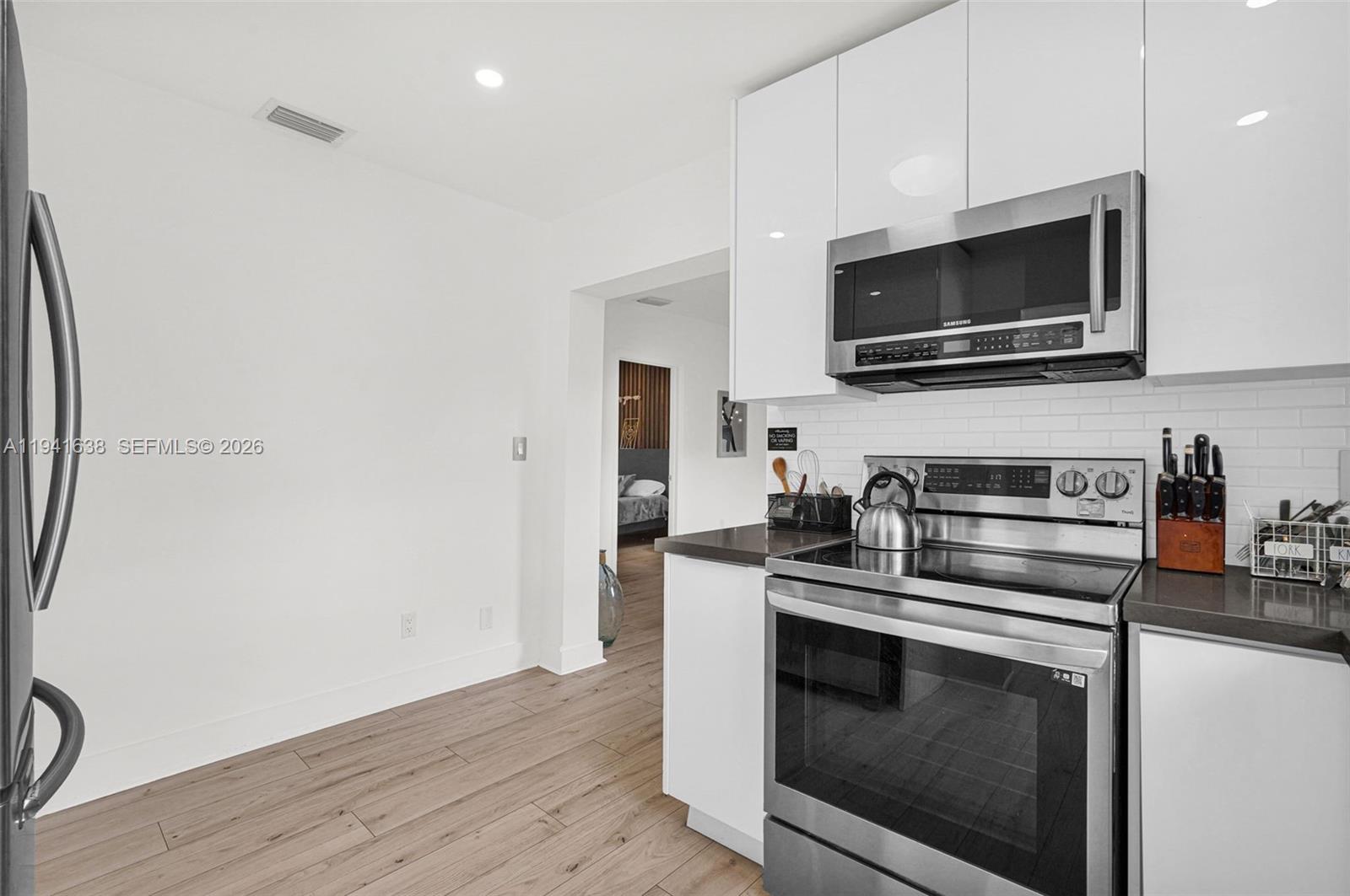 37 Northwest 47th Street Miami, FL 33127 - Photo 31 of 83 a kitchen with stainless steel appliances a stove microwave and sink
