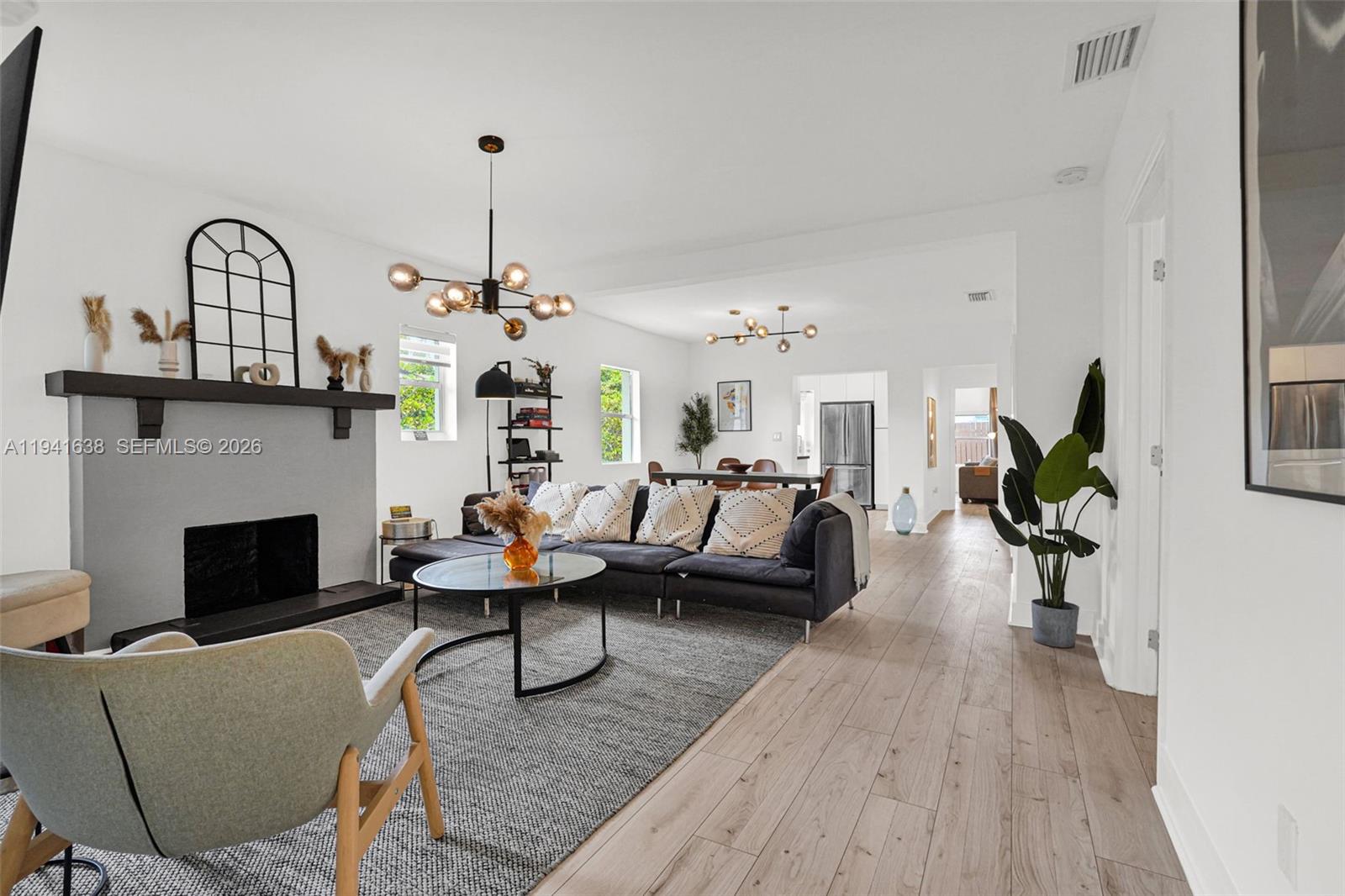 37 Northwest 47th Street Miami, FL 33127 - Photo 53 of 83 a living room with furniture a fireplace and a chandelier