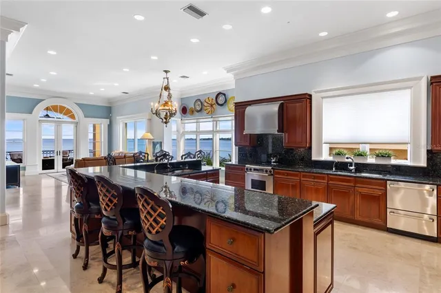 a large kitchen with stainless steel appliances granite countertop a large stove a sink and a refrigerator