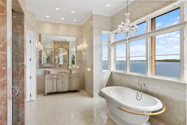 a bedroom with a large bed and a chandelier