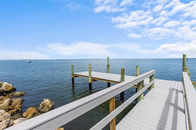 a front view of a residential apartment building with a yard and potted plants