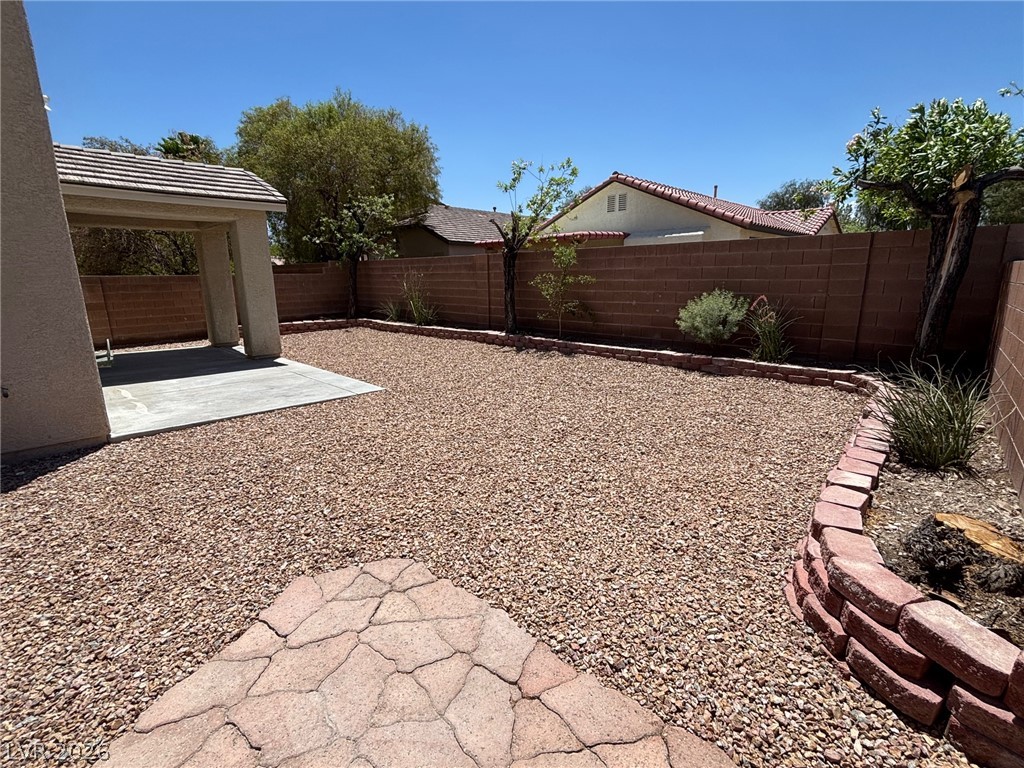 4900 Naff Ridge Drive Las Vegas, NV 89131 - Photo 19 of 21 A spacious, low-maintenance backyard retreat featuring a covered patio and xeriscape landscaping.