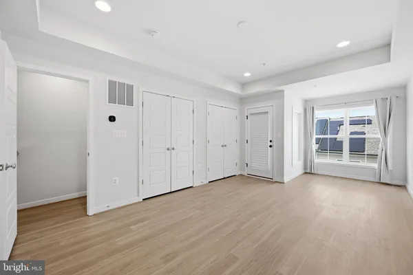 a view of empty room with wooden floor