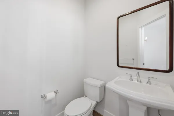 a bathroom with a toilet a sink and mirror