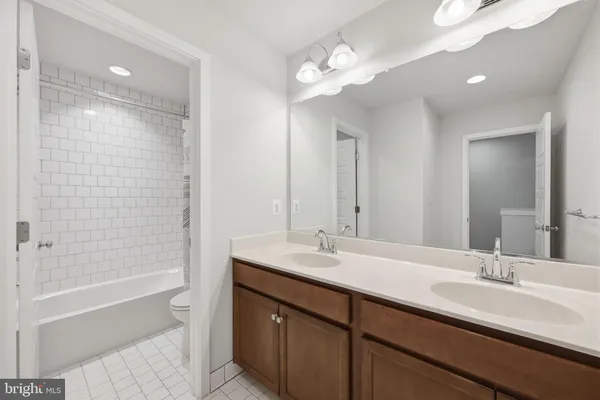 a bathroom with a sink double vanity granite tub shower and a mirror