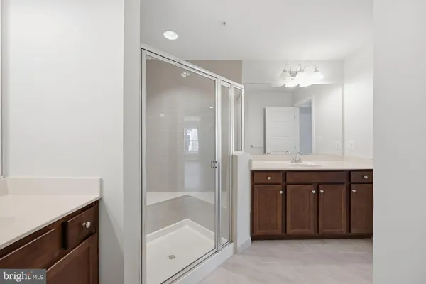a bathroom with a shower sink and mirror