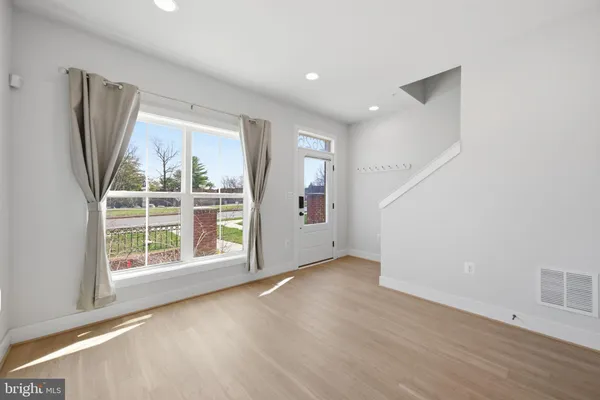 an empty room with wooden floor and a window