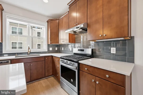 a kitchen with a stove sink and cabinets