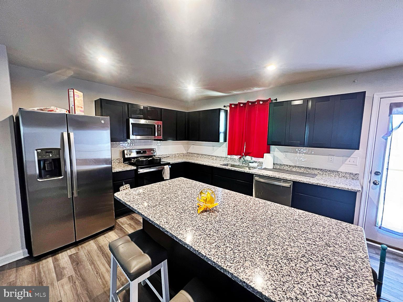 94 Opal Drive Dover, DE 19904 - Photo 6 of 18 a kitchen with stainless steel appliances granite countertop a kitchen island a stove a refrigerator cabinets and a dining table