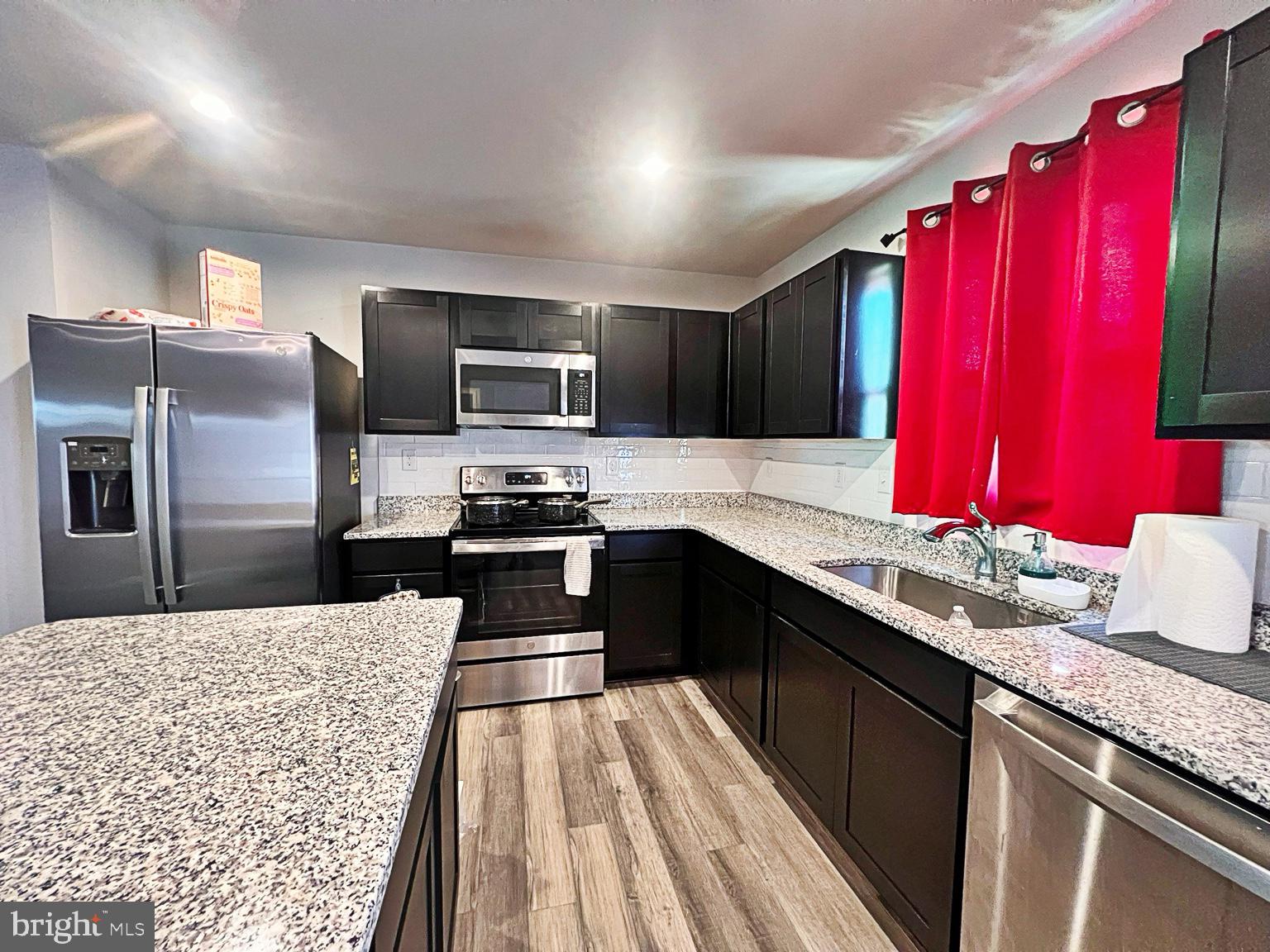 94 Opal Drive Dover, DE 19904 - Photo 7 of 18 a kitchen with stainless steel appliances kitchen island granite countertop a refrigerator a sink dishwasher with a stove and chairs