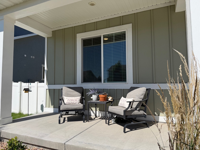 315 South Sherman Street Mapleton, UT 84664 - Photo 2 of 30 Covered front porch featuring a concrete surface, vertical plank siding, a white vinyl fence, and a modern window