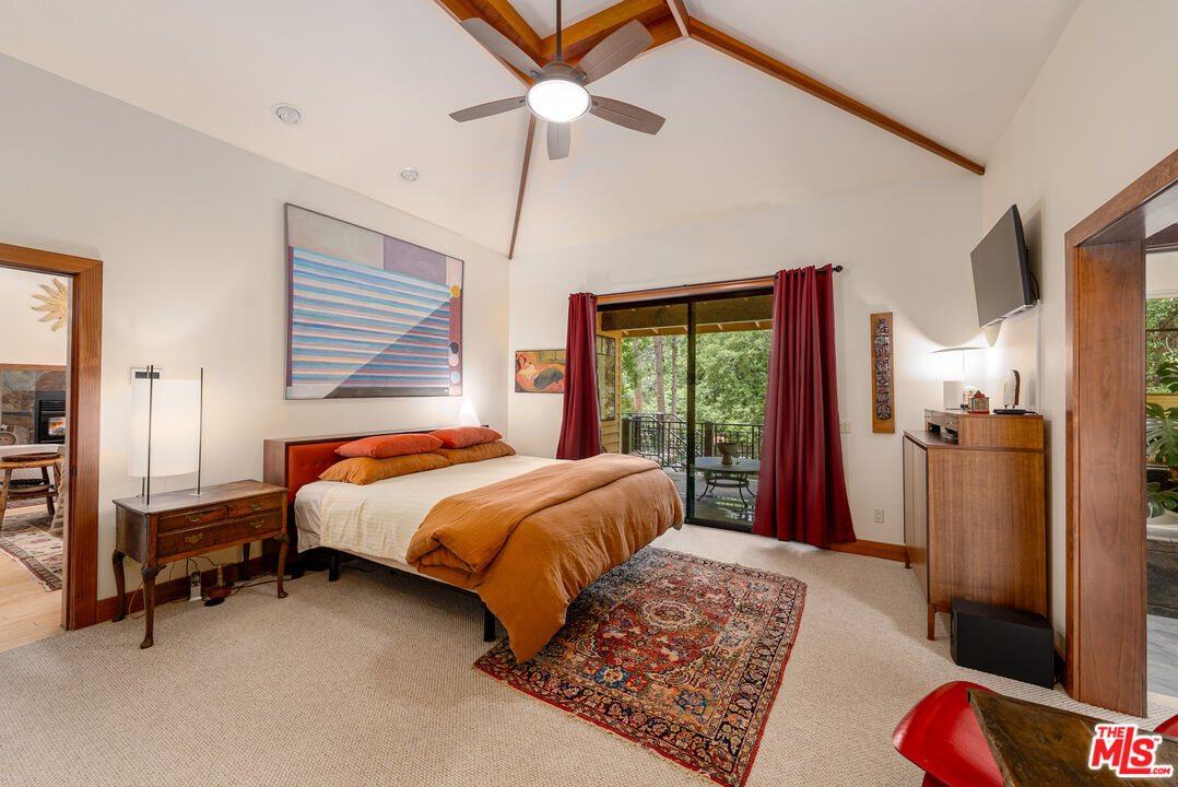 25445 Fern Valley Road Idyllwild, CA 92549 - Photo 15 of 45 a bedroom with a bed a dresser and a chandelier