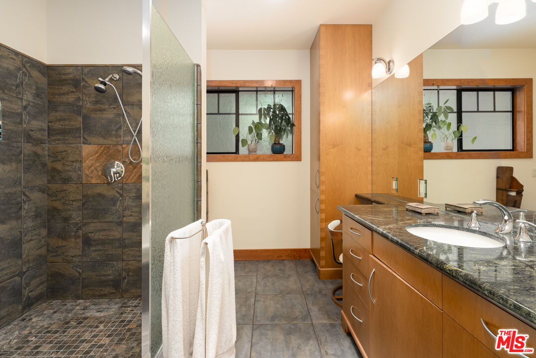 25445 Fern Valley Road Idyllwild, CA 92549 - Photo 21 of 45 a bathroom with a granite countertop shower sink and mirror