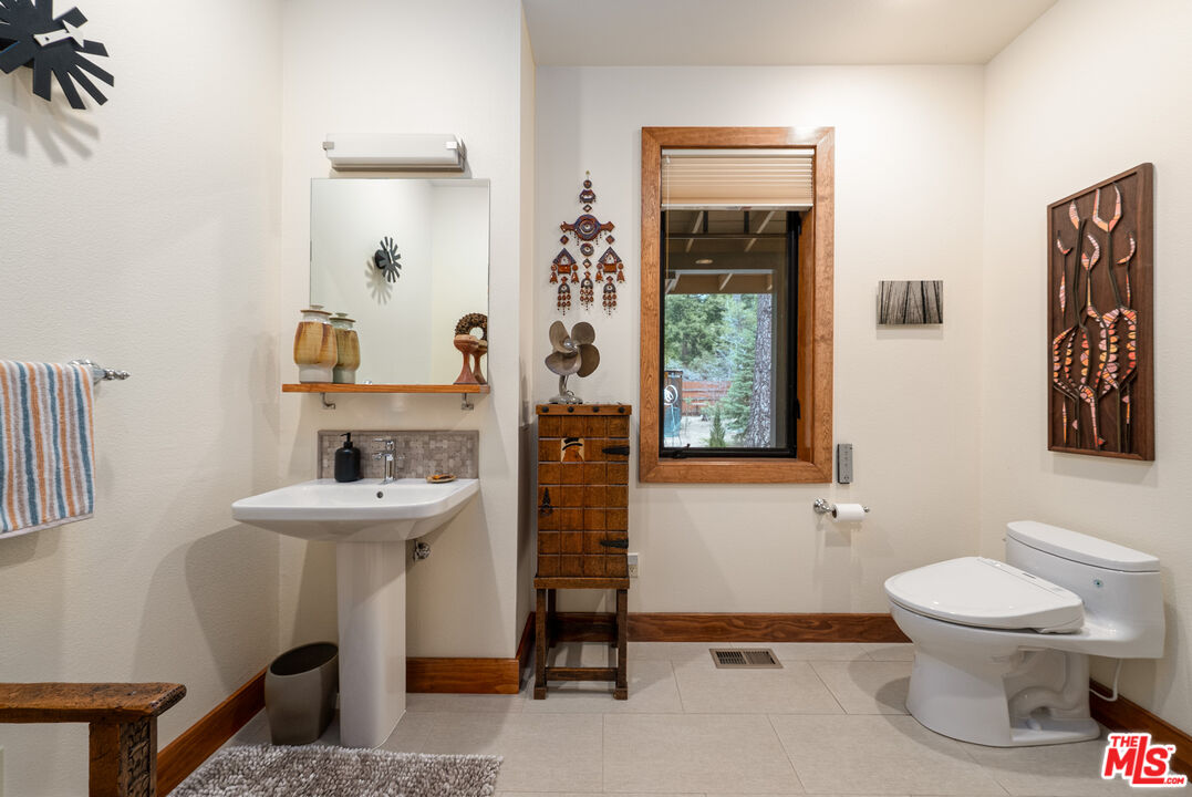 25445 Fern Valley Road Idyllwild, CA 92549 - Photo 23 of 45 a bathroom with a toilet sink and mirror