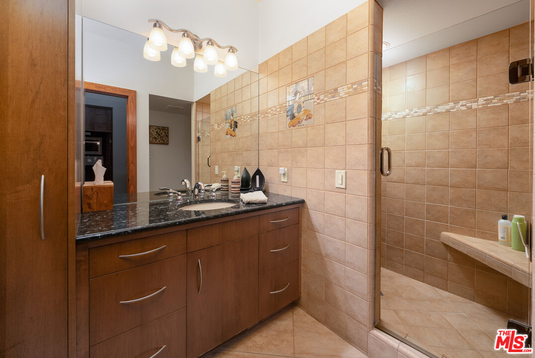 25445 Fern Valley Road Idyllwild, CA 92549 - Photo 25 of 45 a bathroom with a double vanity sink a mirror and shower