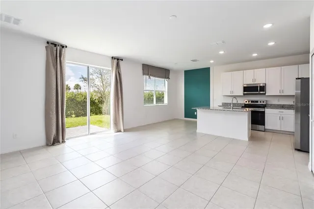 a living room with furniture kitchen view and a flat screen tv