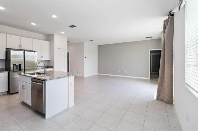 a kitchen with stainless steel appliances granite countertop a refrigerator stove a sink a microwave oven and a refrigerator