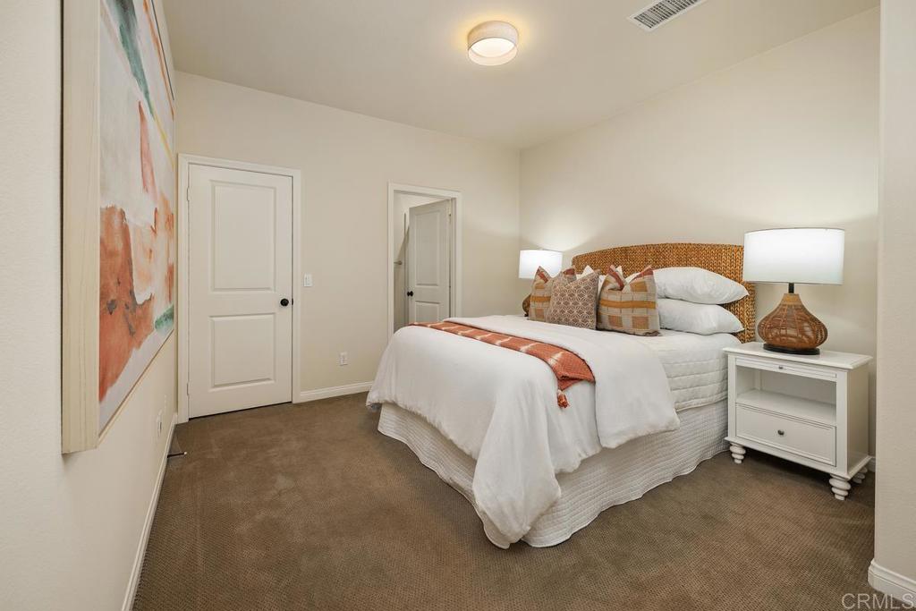 7603 Circulo Sequoia Carlsbad, CA 92009 - Photo 18 of 61 a bedroom with a bed and a lamp