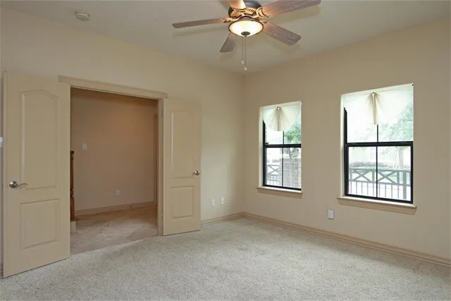 an empty room with windows and closet