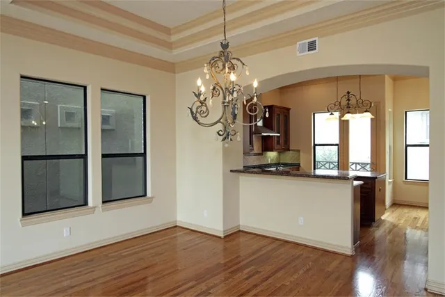 a view of a room with wooden floor and chandelier