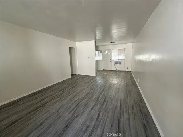 a view of a room with wooden floor and a window