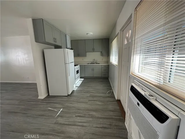 a view of a kitchen with wooden floor and electronic appliances