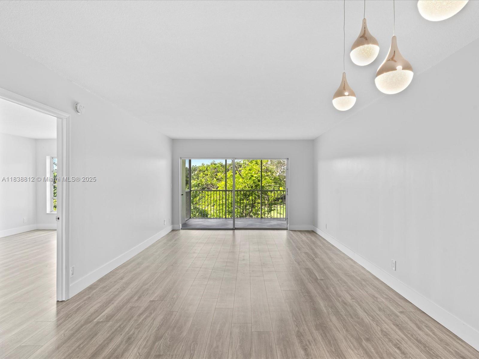 Palm Aire Pompano Beach, FL 33069 - Photo 11 of 26 an empty room with wooden floor and windows
