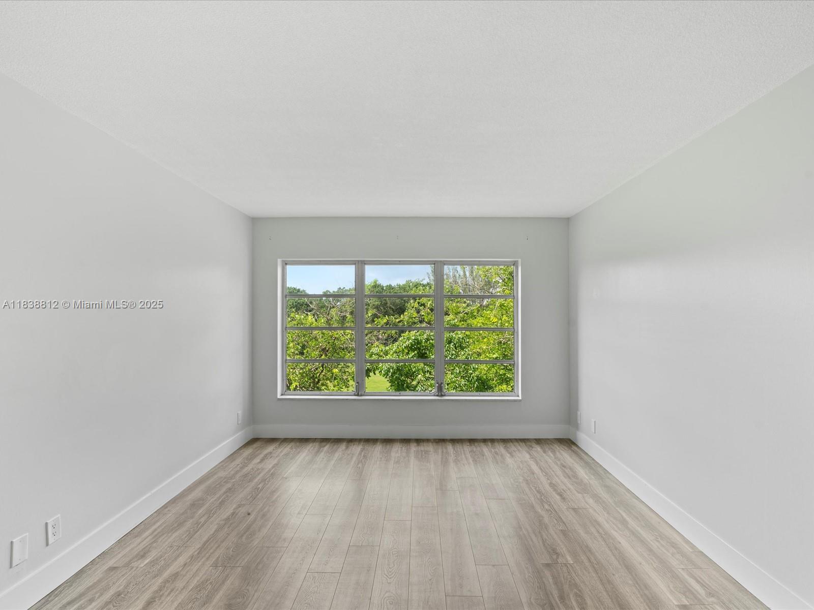 Palm Aire Pompano Beach, FL 33069 - Photo 16 of 26 an empty room with wooden floor and windows