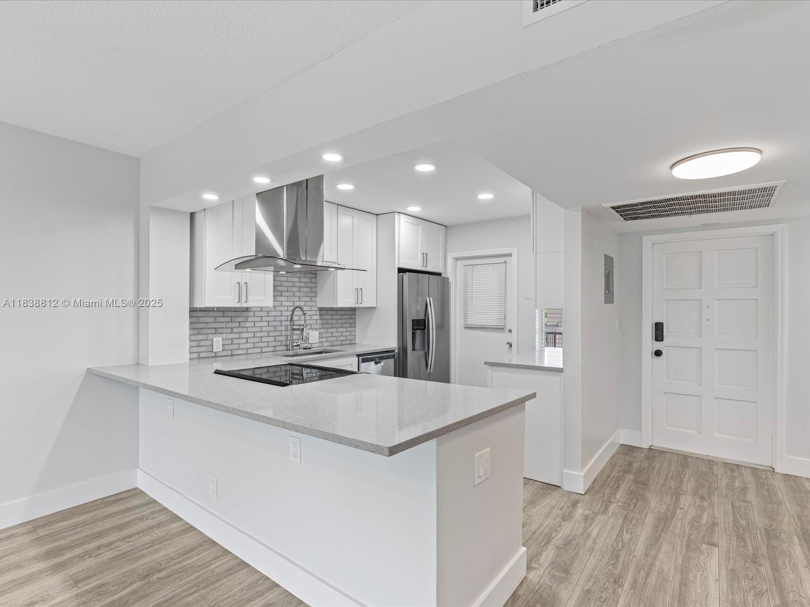 Palm Aire Pompano Beach, FL 33069 - Photo 7 of 26 a large kitchen with kitchen island a sink stainless steel appliances and cabinets