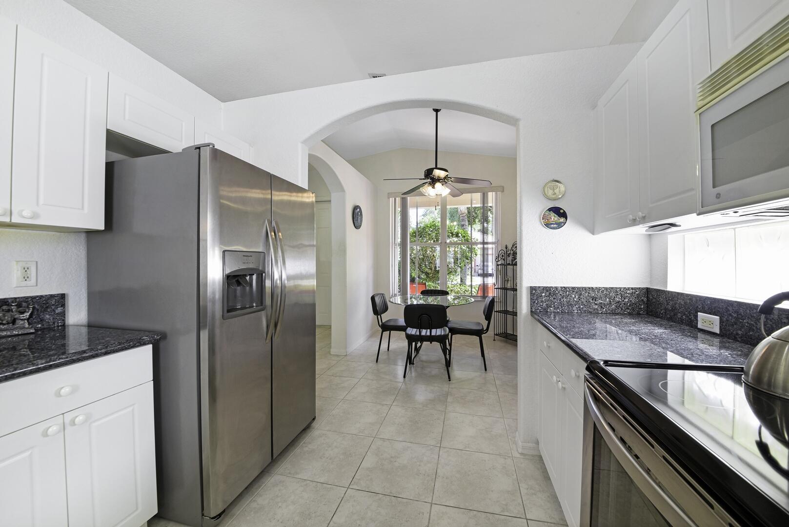 8214 Bellafiore Way Boynton Beach, FL 33472 - Photo 7 of 35 a kitchen with stainless steel appliances granite countertop a sink and a refrigerator